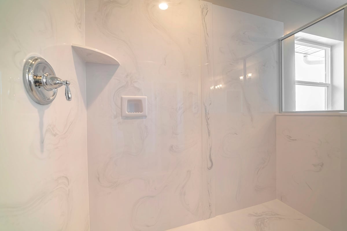 Modern white marble bathroom with glass shower screen, contemporary design and clean finishes