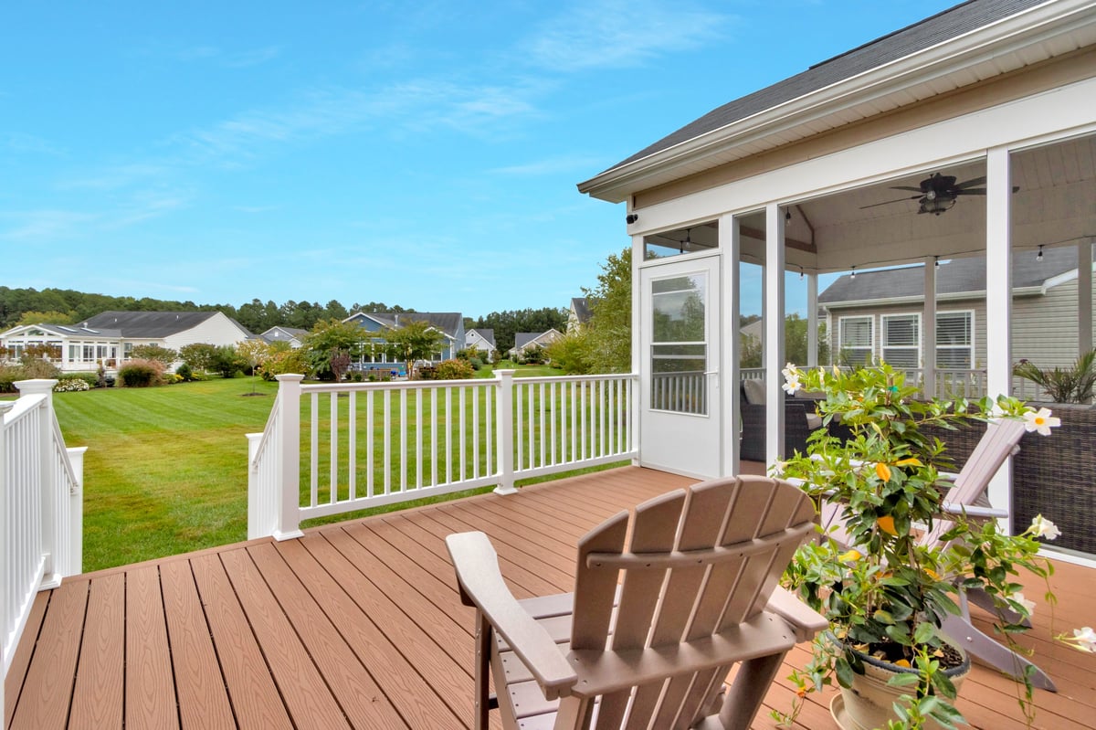 Elegant deck space with comfortable Adirondack chairs overlooking green space, perfect outdoor relaxation area