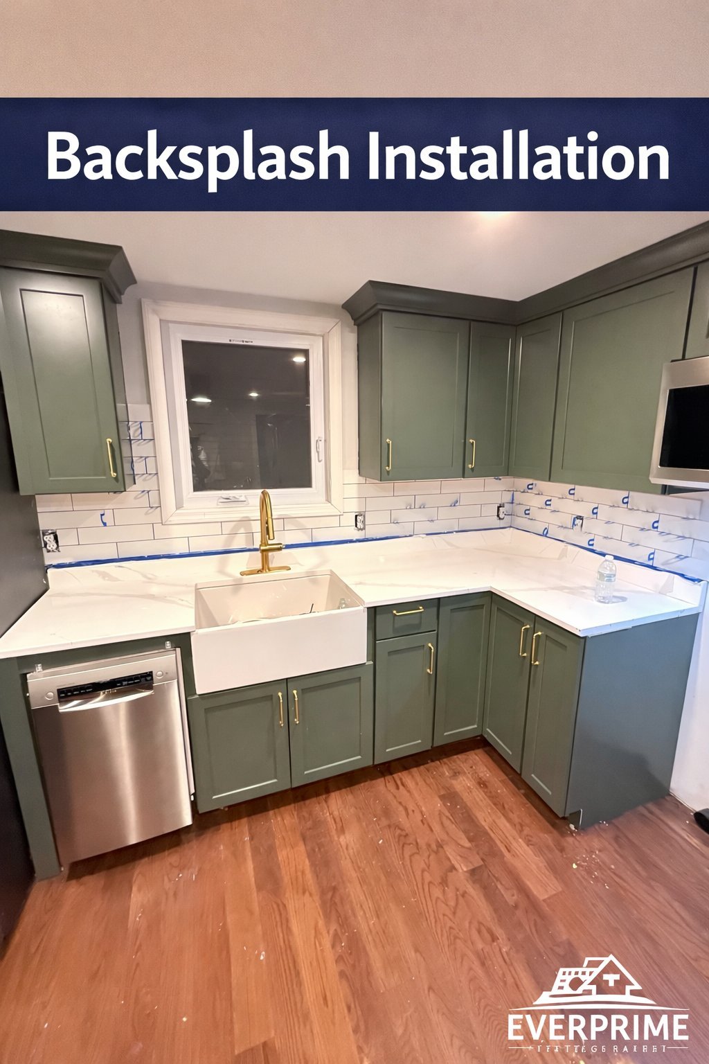 Modern kitchen with white subway tile backsplash, green cabinetry, farmhouse sink, and wood flooring during installation